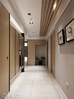 廊道周建志设计师刻意不将收纳做满，预留摆放冰箱的位置提升变动弹性；柜体运用灯光设计照映出壁纸精致质感，藉由木纹延展和黑色线条隐藏起书房门片。 