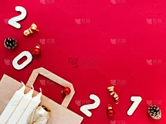 制作圣诞装饰品，纸袋，白色蜡烛，锥形，红色纸背景上的2021数字。圣诞作文，俯视图，平铺，复制空间。