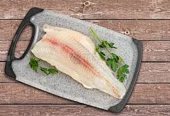 将生盘古鱼片与欧芹叶放在切菜板上