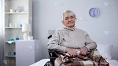 悲伤的奶奶坐在轮椅上盖着毯子，敬老院孤独