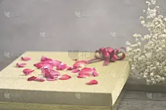 低不透明度和散焦的金色礼盒和玫瑰花瓣的背景和贺卡或礼物