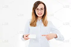 美丽微笑的女商人与名片孤立在白色的背景。年轻女孩与卡片摆姿势。本空间