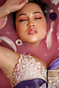 美丽的女人肖像与鲜花和花瓣在玫瑰水。滋润皮肤的化妆品