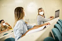 女学生戴防护口罩在报告厅进行病毒防护