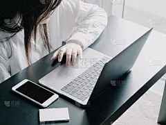 从亚洲商业女性(30 - 40岁)的头顶视图，白色衬衫，把她的智能手机，名片盒和使用电脑笔记本电脑支