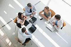 Business People In a MeetingTop view of business people having discussion while sitting around at conference table in board room.