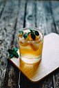 A cold cocktail whiskey with leaves on a table