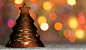 andreaobzerova在 500px 上的照片Xmas tree shaped candle holder standing in snow, with christmas tree lights, bokeh background and co