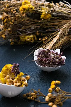 时髦的复活节装饰品。打碎的有机鸡蛋与干草和干花在盘子里。鸟的羽毛。副本的空间。贺卡。暗的背景