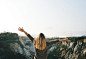 Woman With Blonde Hair at the Top of the Mountain Raising Her Hands