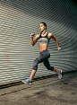 Allison Short : Female athlete working out / running  in urban setting with audio headphones. 