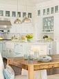 Coastal-inspired kitchen - white & wood with light-blue accents in open shelving & glass-fronted cabinets.