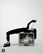 This may contain: a woman leaning on top of a tv