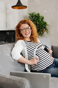 兴奋的准妈妈把耳机放在肚子上
