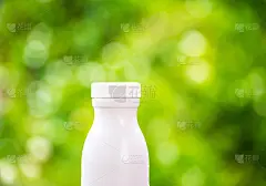 瓶子塑料白色的木材和树木模糊的散景背景在花园里。使用壁纸包装与产品形象。