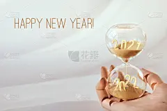 沙漏，从2021年到2022年的时间流逝。木制艺术模型手握时间玻璃。寒假倒计时。新年祝福语