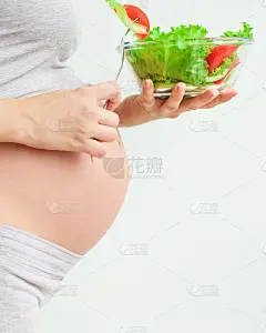 健康的营养和怀孕。孕妇的肚子和蔬菜沙拉。孕期营养。素食主义和怀孕。孕期维生素，孕期饮食
