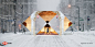 a man walking through a tunnel in the middle of a snow covered street with traffic lights