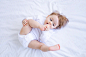 funny-baby-girl-playing-with-her-feet-bed-white-clothes-smiling-top-view-small-child-cotton-bed-home-woke-up-morning-after-sleeping-concept-children-s-goods_267293-5925 (1)