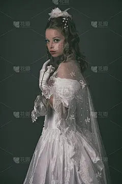 维多利亚时代穿着白色连衣裙的时尚女性。拿着手提包。