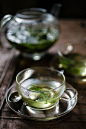 A cup of sage tea on a desk,with teapot within the background. by Darren Muir  #tea... #teaphotography