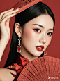 一位中国美女戴着红色背景的耳环，半身照，皮肤白里透红，侧面特写，穿着红色旗袍。她有长长的睫毛，一只手拿着一把红扇子，她妆容精致，姿态优雅，回眸一笑，色彩艳丽，氛围神秘。张静娜的风格 (1)