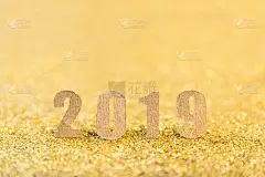 2019年新年文字与牛皮纸在金色闪闪的背景。新年快乐的背景与复制空间