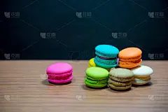 彩色的马卡龙堆和粉红色的马卡龙在木桌和黑色的背景。图片的背景，壁纸和复制空间。添加广告文字