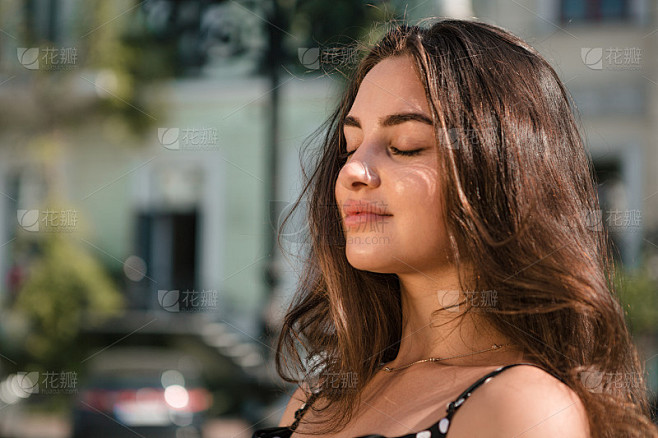 在温暖的夏天，穿着黑色连衣裙的漂亮年轻女...