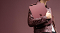 时尚的女人将酒红色 Surface Laptop 抱在胸前。