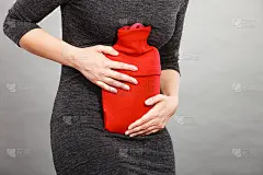 女孩胃疼，拿着热水瓶