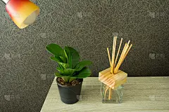 现代的工作场所，木桌上有花盆和芦苇清新剂