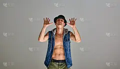 年轻的霹雳舞舞者在帽架与手在工作室孤立的灰色背景。舞蹈学校的海报