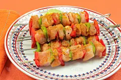 brochette cru de dinde et poivrons avec des épices dessus (curry) dans une assiette