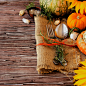 Seasonal wooden table setting with small pumpkins