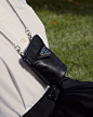 Photo by Prada on December 14, 2020. May be an image of saddle-stitched leather, purse and outerwear.