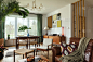现代斯堪的纳维亚家庭室内客厅设计复古家具，热带棕榈树，画廊墙，装饰和优雅的个人配件是在时尚的家庭装饰