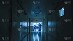 医院急救小组抬着病人担架穿过黑暗的医院大厅。