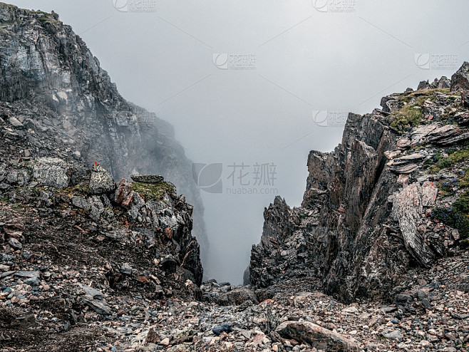 高海拔悬崖上的山景。神秘的景观，悬崖附近有美丽的尖锐的岩石和低云的颜色。美丽的山雾风景在深渊边缘与尖 