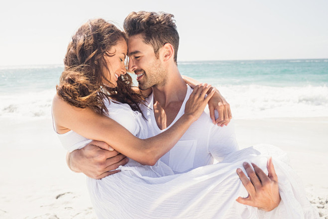 海边沙滩抱起来的情侣图片