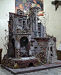 This may contain: a model of an old building with fruit on the outside and brickwork around it
