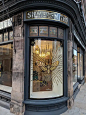 This may contain: a store front with an ornate glass window
