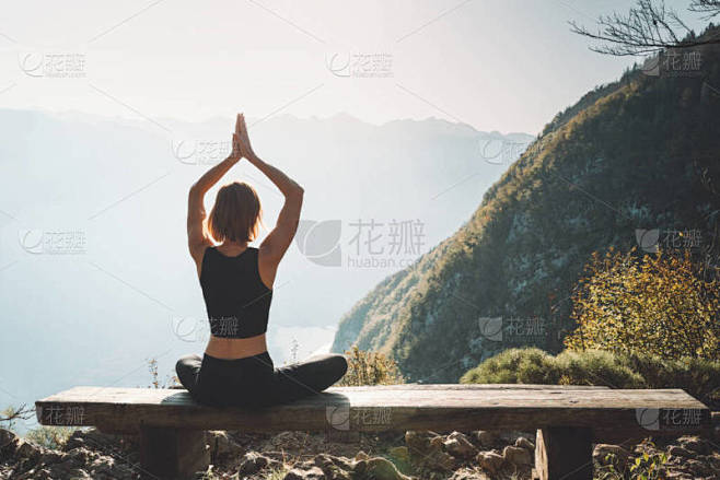 女性在大自然中练习瑜伽。年轻女子在高山的...