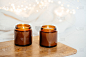 两支戴着墨镜的蜡烛放在木板上。白色背景和花环。祝你新年精神好。节日的灯光和蜡烛。