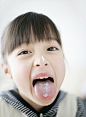 Japanese girl showing cream on tongue and nose with looking at camera