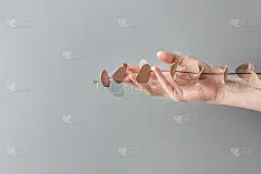 年轻白种人女子优雅美丽的手在灰色的墙壁背景上拿着干银元桉树树枝。温暖的秋季色调。花店的海报