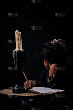 可爱的小女孩在烛光下学习