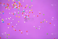 紫色的背景与生动的五彩纸屑。彩色抽象背景与分散的纸圈。派对的装饰真漂亮。庆祝的节日作文。从以上观点。