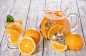 健康的橙排毒与新鲜的橙和酸橙，在玻璃上的木制背景。