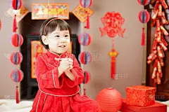 中国女婴的传统装扮庆祝中国新年，反对各种“FU”意为“幸运”的装饰和贺卡背景